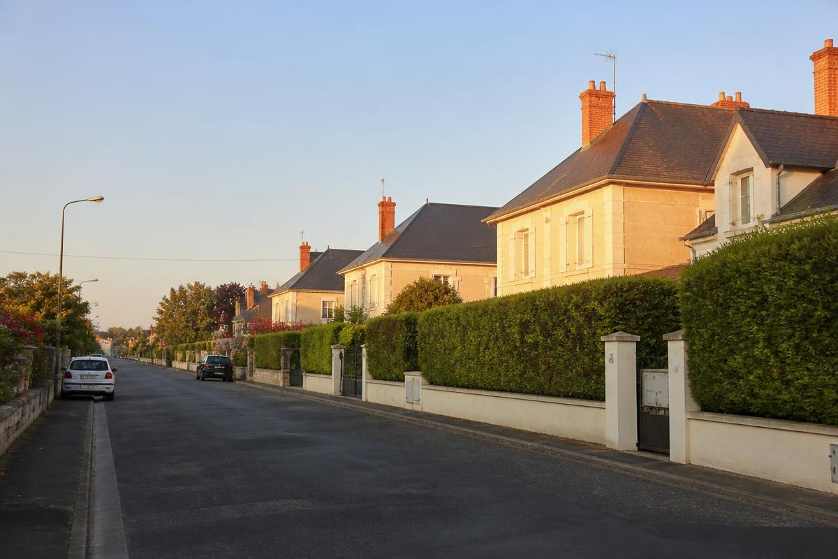 Rue résidentielle calme en Touraine avec des pavillons et des haies bien entretenues